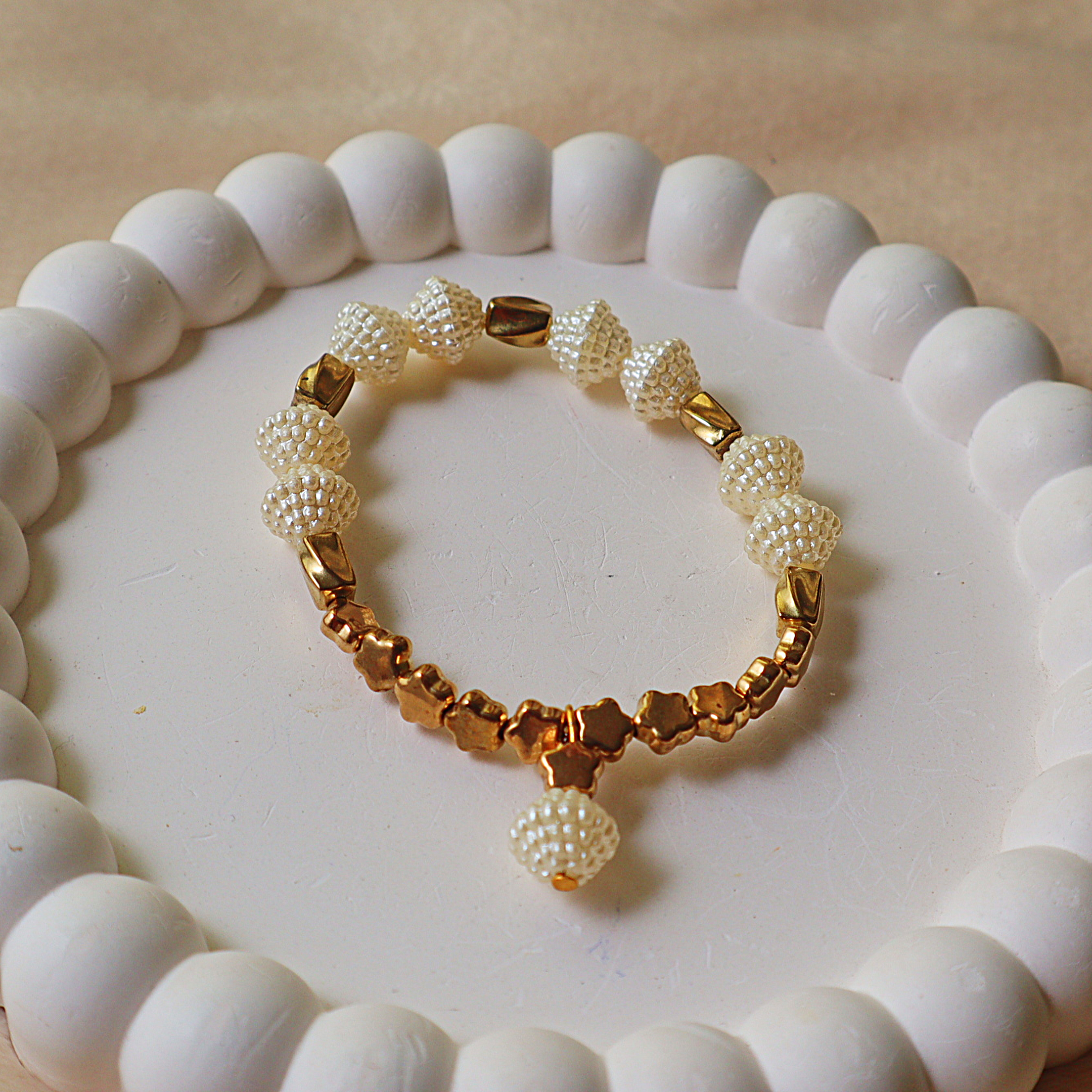 Product Title Options  Primary SEO Title: Elegant Woven Pearl & Metallic Gold Star Stretch Bracelet – Textured Pearl Beads with Gold Star Accents & Pearl Dangle Charm