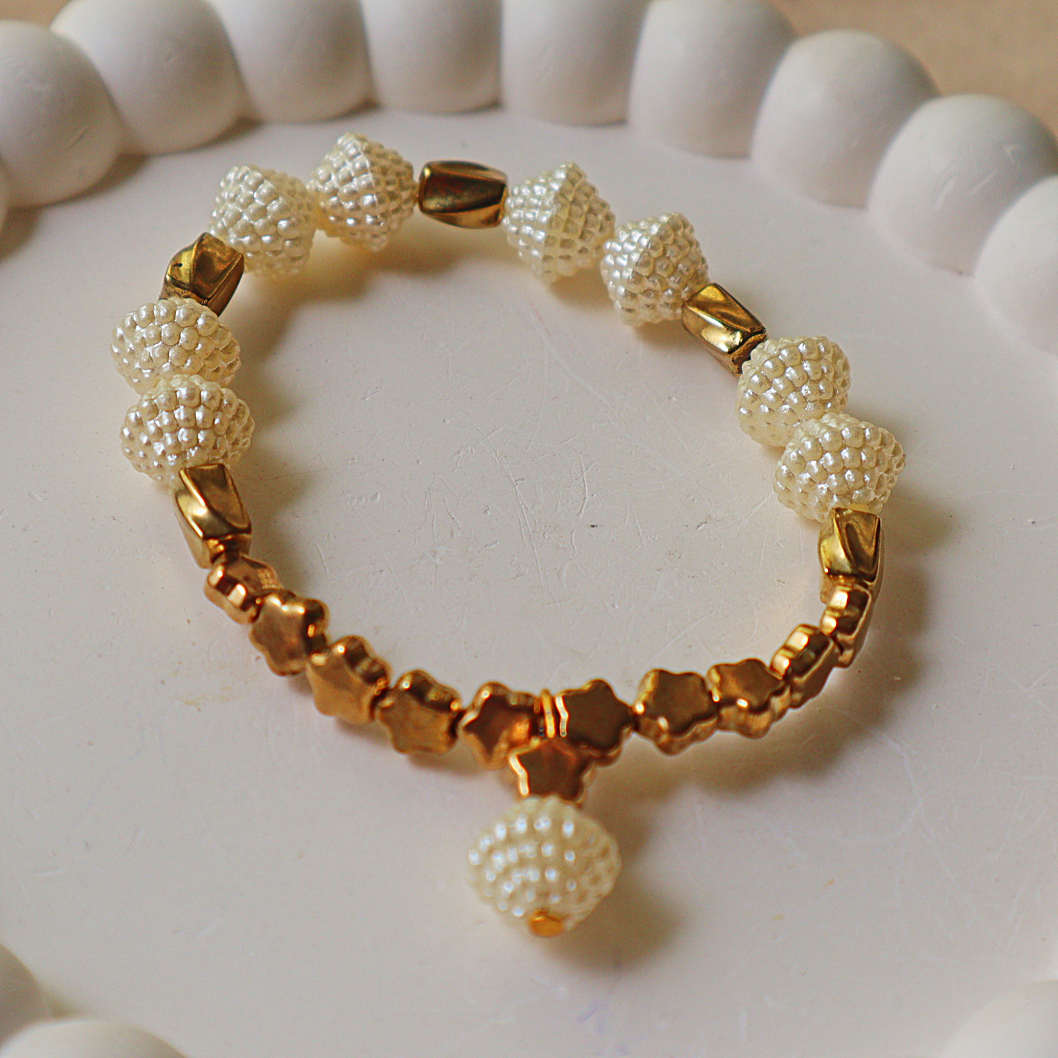 Product Title Options  Primary SEO Title: Elegant Woven Pearl & Metallic Gold Star Stretch Bracelet – Textured Pearl Beads with Gold Star Accents & Pearl Dangle Charm