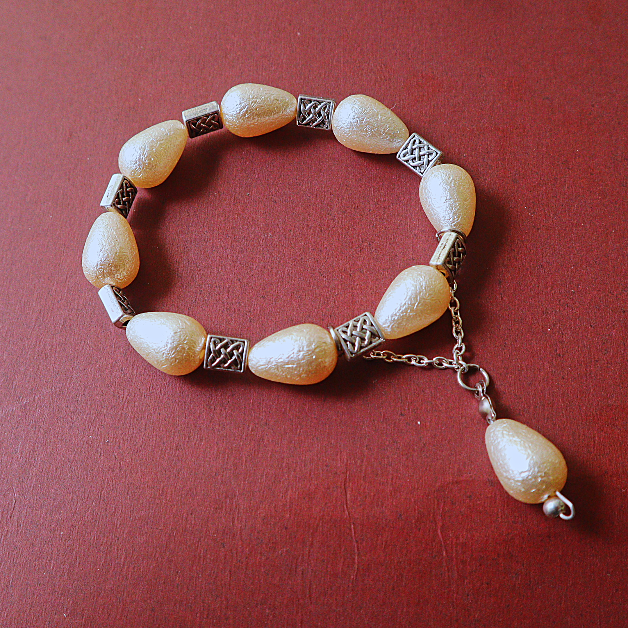 Ivory Pearlescent Drop Bead Bracelet with Silver Celtic Knot Spacers & Dangle Drop