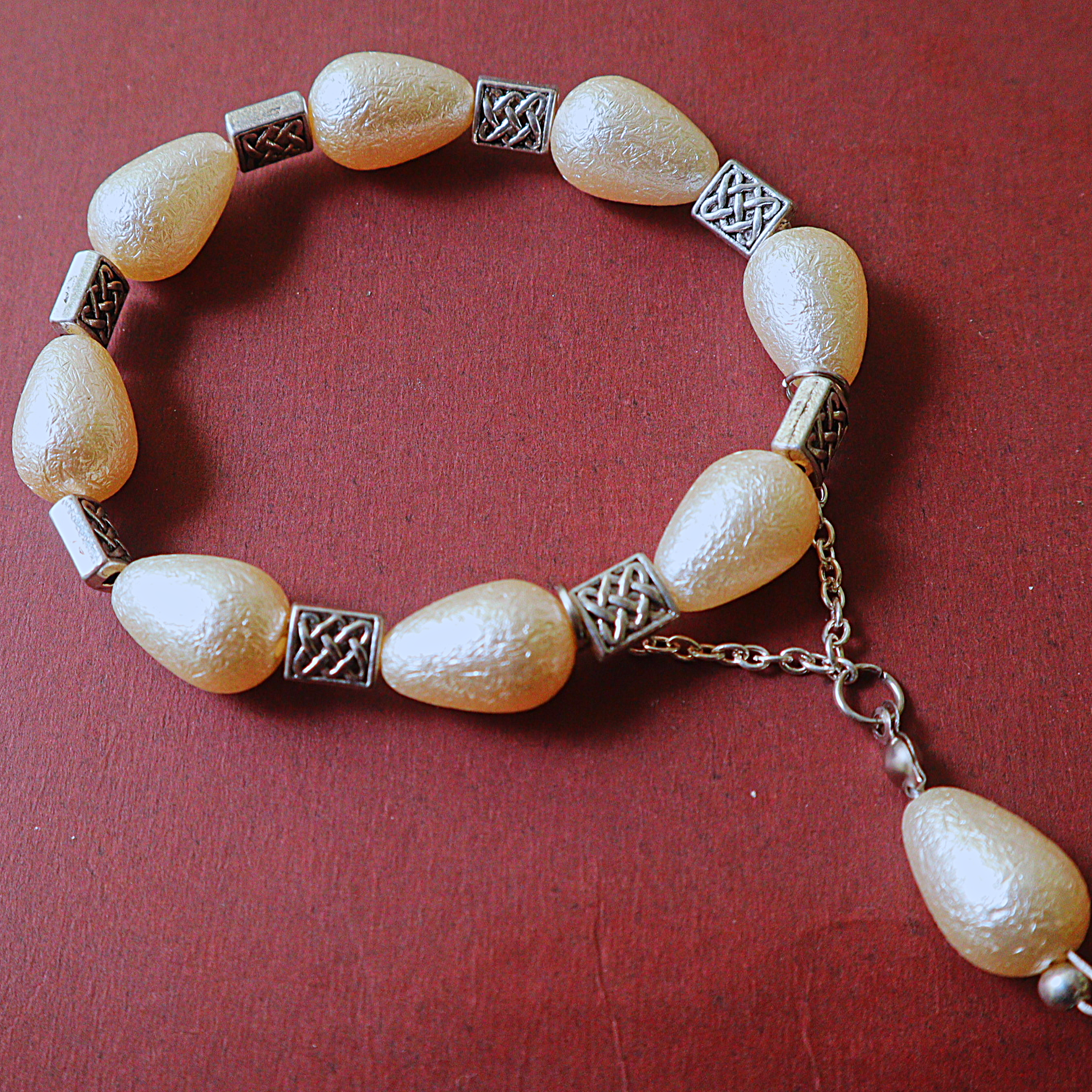 Ivory Pearlescent Drop Bead Bracelet with Silver Celtic Knot Spacers & Dangle Drop